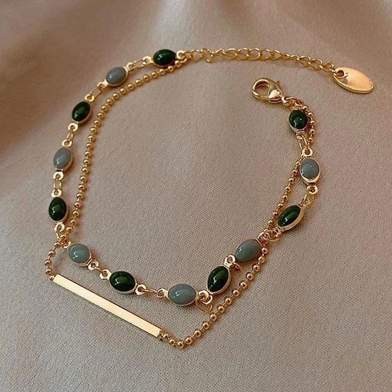 Armbånd med grønne sten i guld